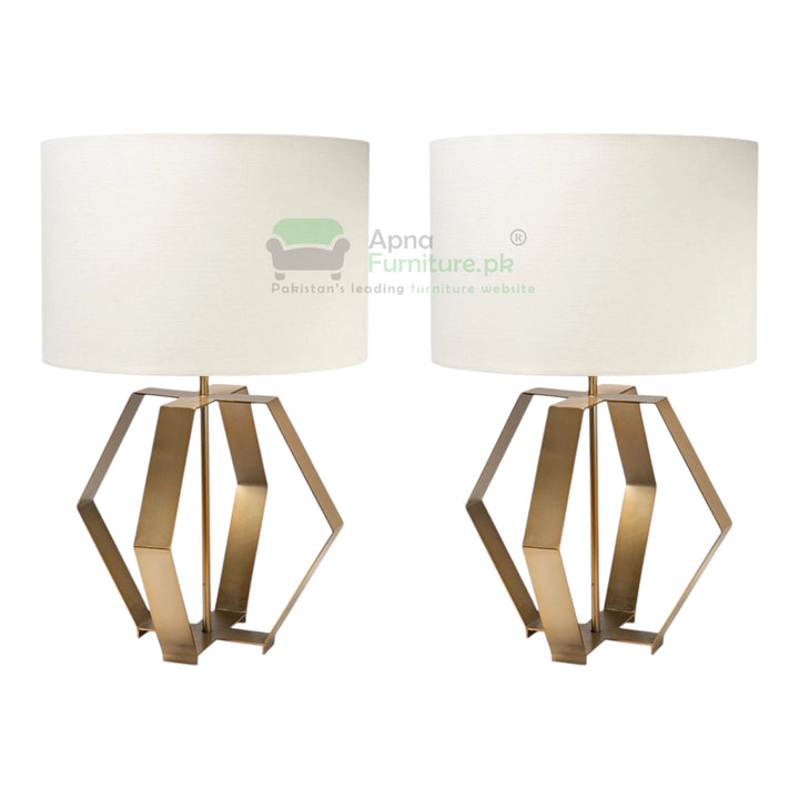 Two table lamps with gold geometric bases and white shades on a white background.